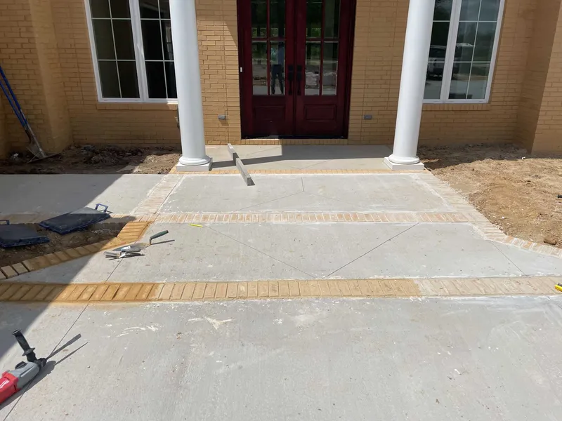 Concrete entrance with a contrasting decorative brick border