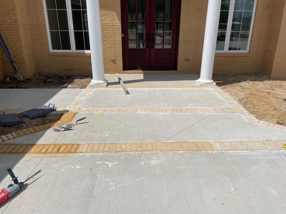 Finished concrete entry bordered with brick
