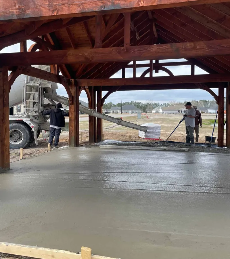 Concrete crew pouring and finishing a pad